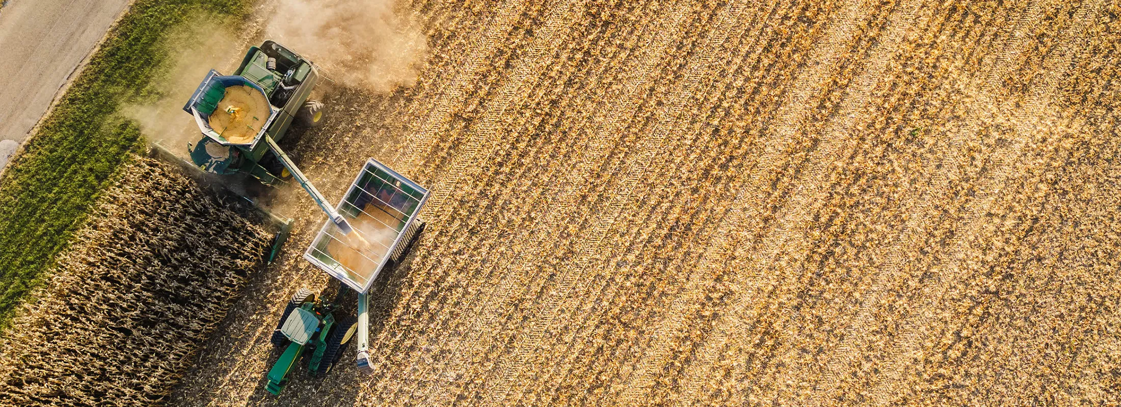 aerial view of a combine harvester unloading into a grain cart