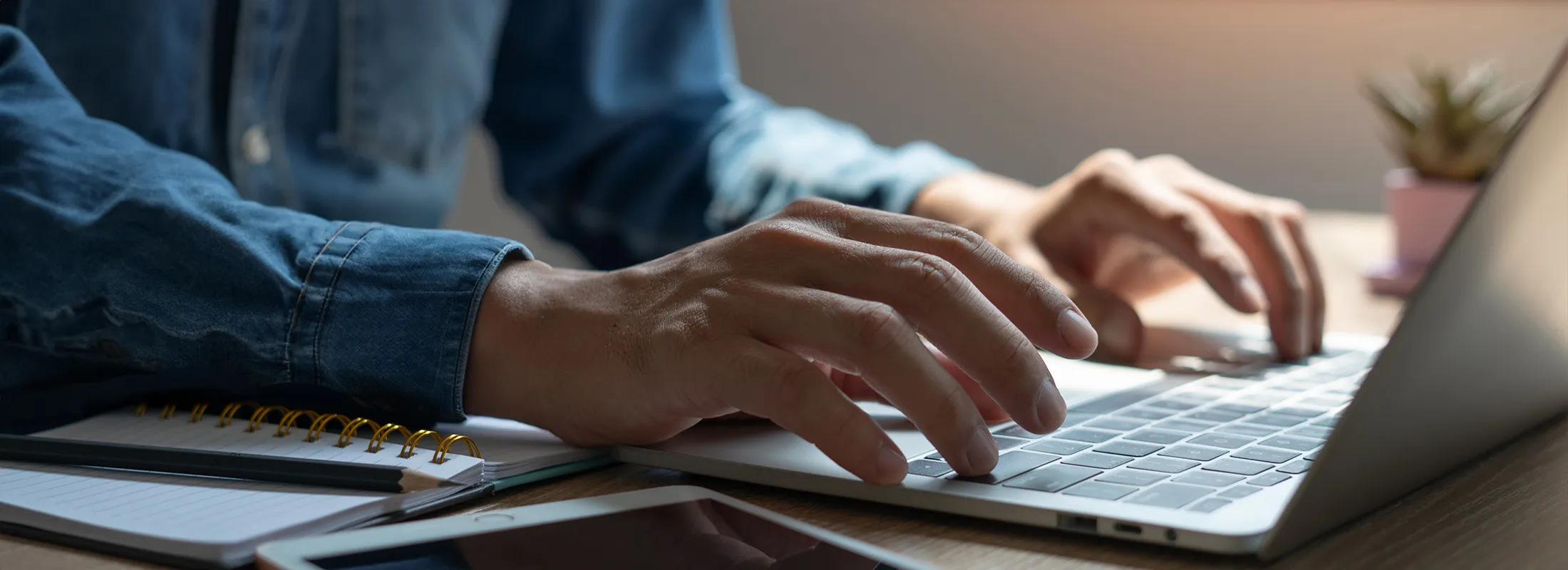 a close up of hands typing on a laptop keyboard
