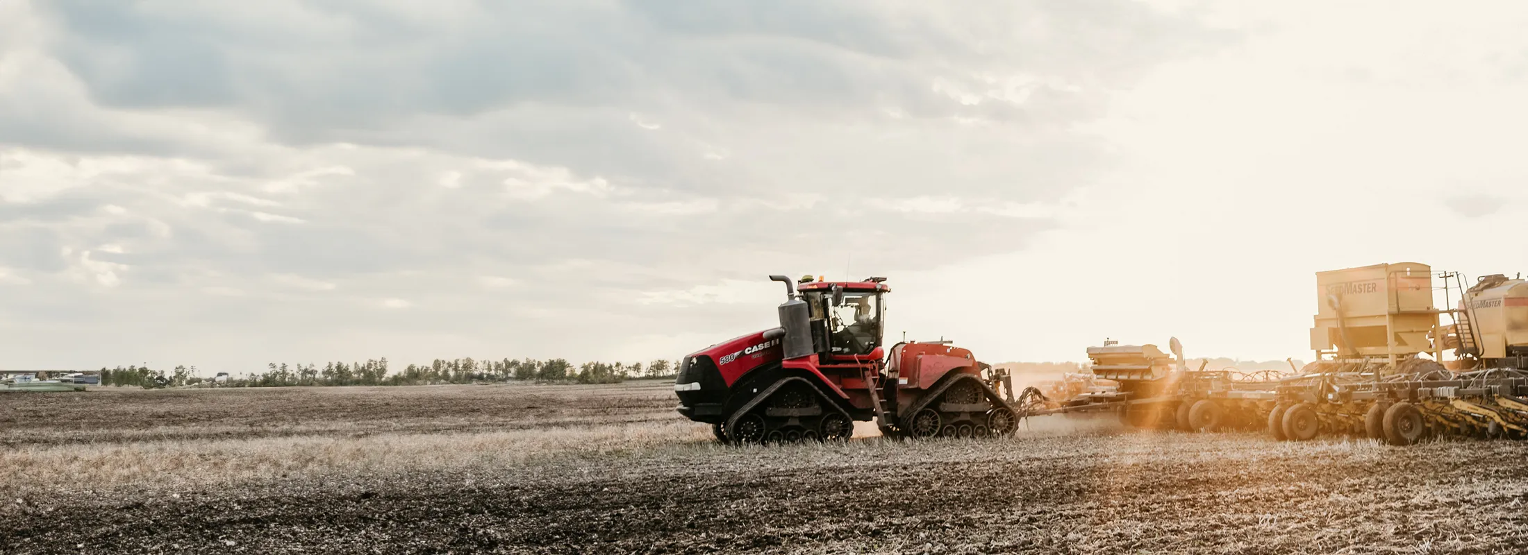 a tractor pulling an air seeder across a field