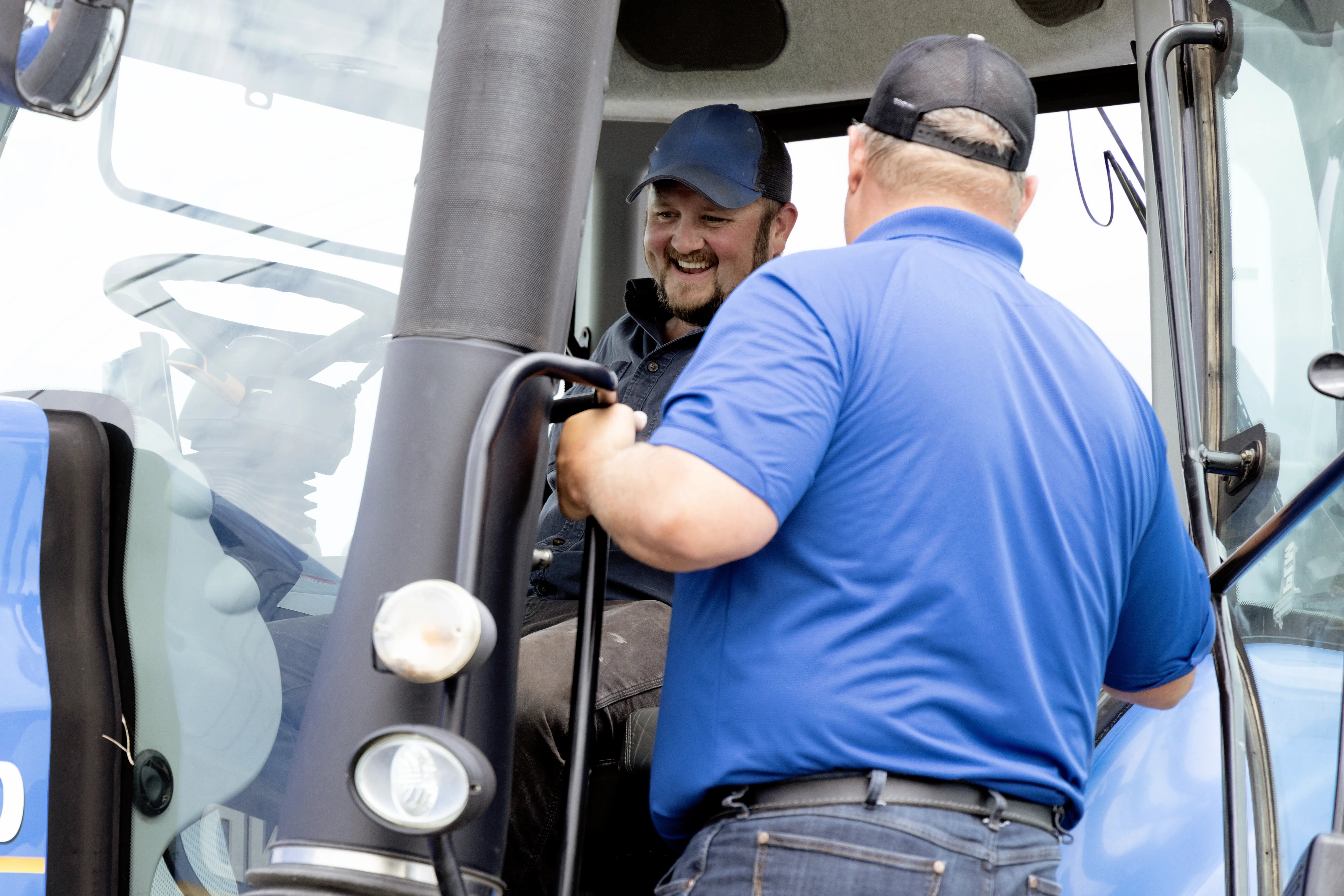 2 people talking while in a tractor cab