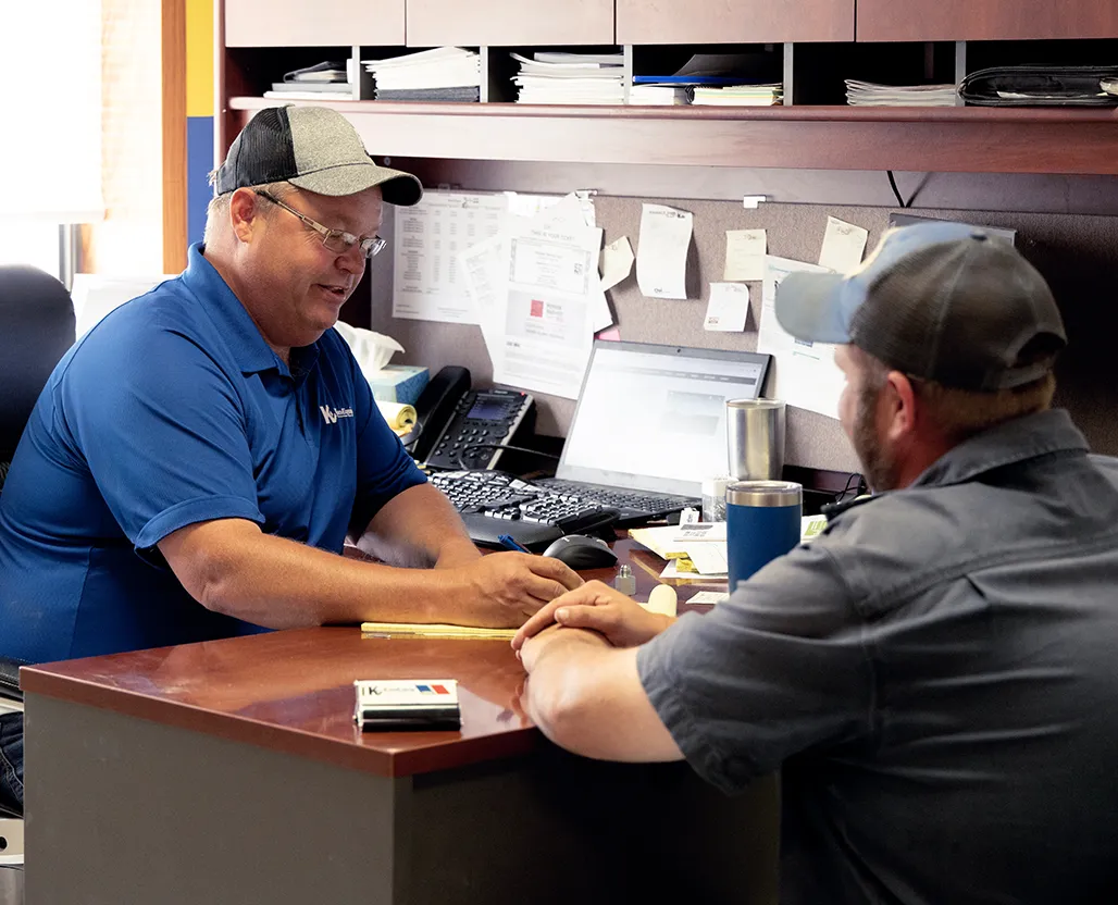 two men sitting in office at desk