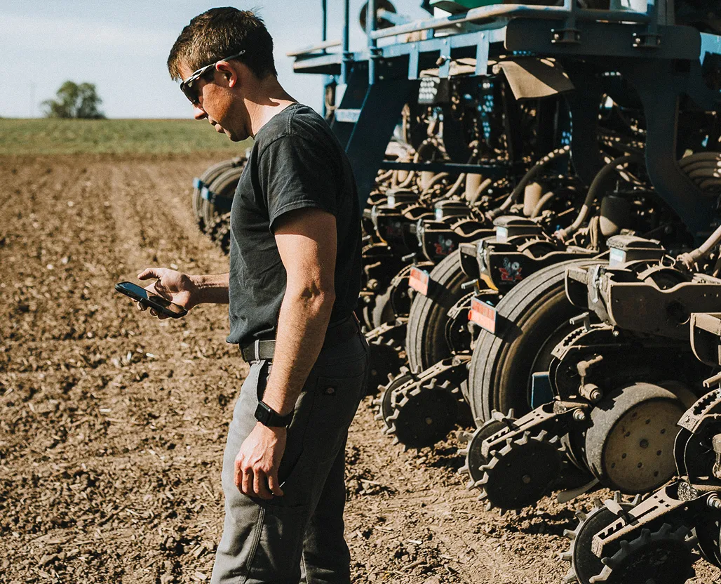man using phone in field