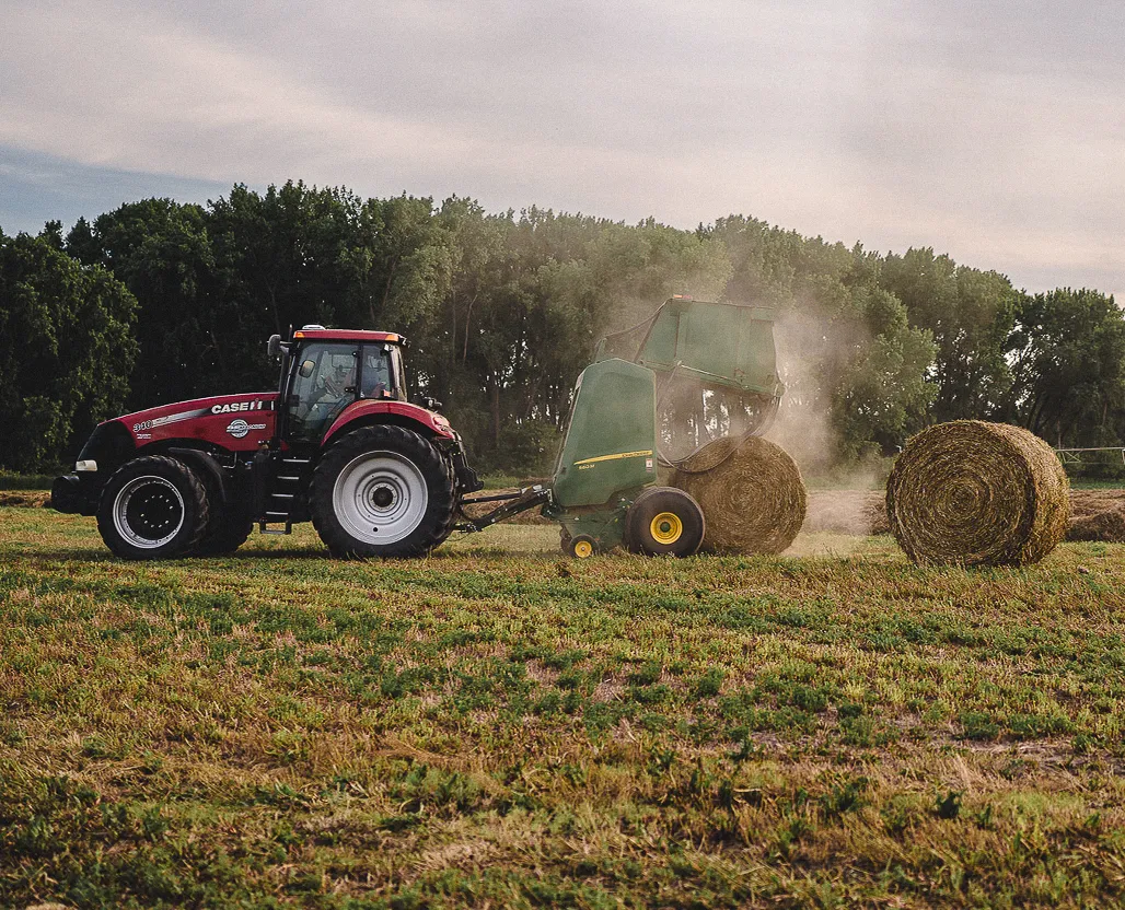 tractor and baler baling hay